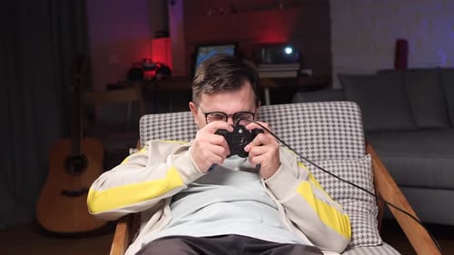 Man Plays Video Games in Living Room Chair