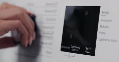 Selective Focus on Hand Selecting Laundry Settings on Stateoftheart Digital Display