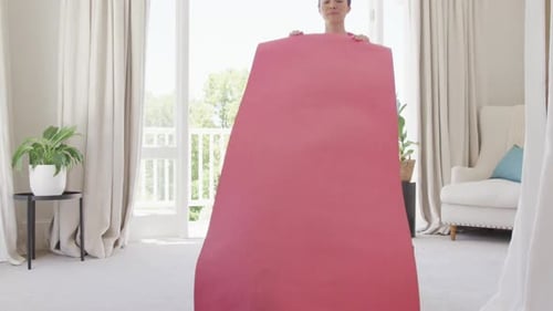 Happy asian woman placing yoga mat in bedroom, in slow motion