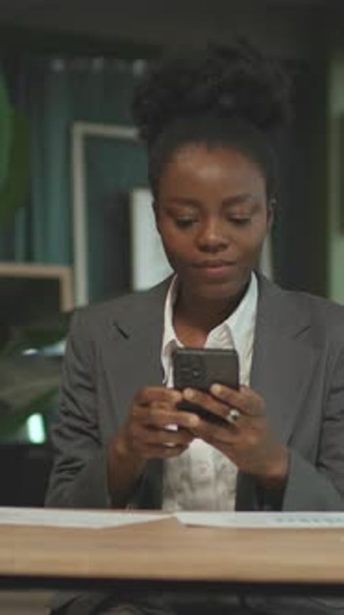 Focused Woman Using Smartphone in Modern Office