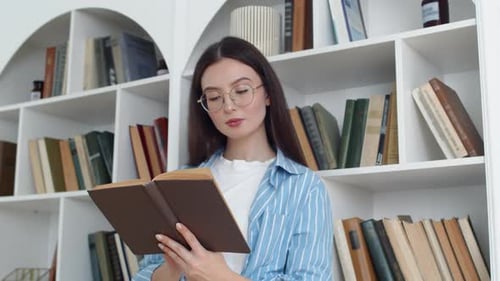 Woman Reading Book by White Bookshelf