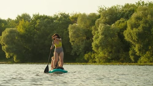 Stand Up Paddle Boarding In River In Summertime Women Practicing SUP Touring Sport