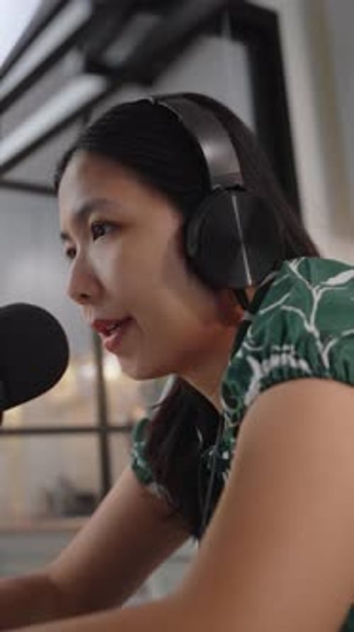 Woman recording voiceover with a microphone and headphones