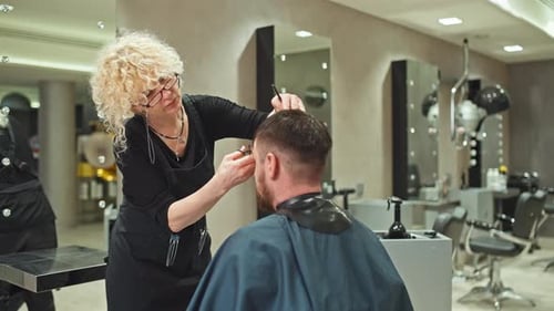 Hair Stylist Cutting Man's Hair in Stylish Salon
