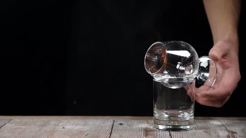 Arm Holding Burning Cocktail Drink with Shot Glass