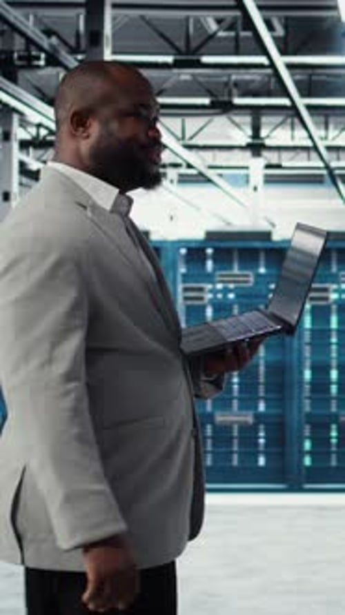 Vertical Video Smiling Data Center Programmer Using Laptop to Upgrade System Stability