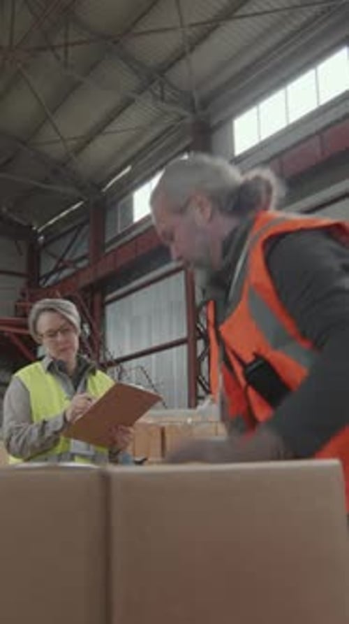 Male Warehouse Worker Loading Packages into Car and Talking to Forewoman