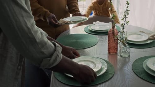 Family Sets Table for Dinner at Home