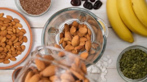 Top View Almonds Slowly Falling Into Blender to Grind Into Almond Flour or Plantbased Almond Milk