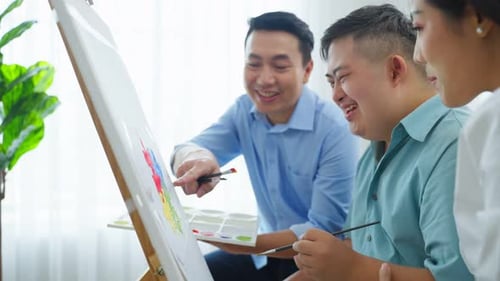 Cheerful People Painting Together on a Canvas