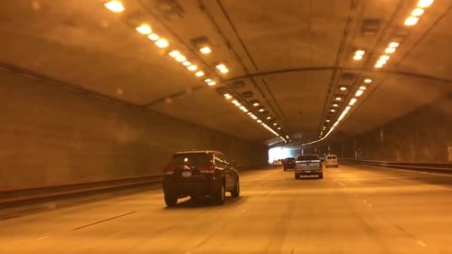 Cars driving inside a tunnel in the highway.