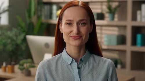 Smiling Woman with Red Hair Poses in Office