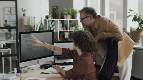 Software Developers Collaborating on Code in an Office