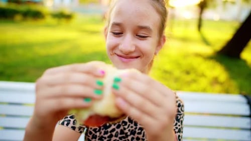 Top View Caucasian Teen Girl Bites and Eats Mouthwatering Tasty Hot Burger