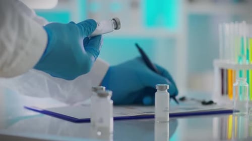 Portant des vêtements spéciaux, un employé expérimenté de l'entrepôt de pharmacie enregistre soigneusement les informations