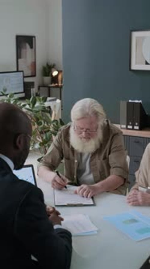 Senior Man Signing a Corporate Agreement in Office