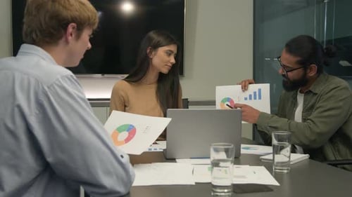 Business Team Reviews Charts and Graphs in Meeting