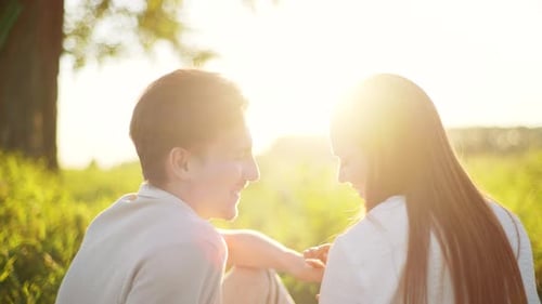 Closeup of Loving Young Couple Kissing Sitting in Wheat Field Having Romantic Date on Blurred
