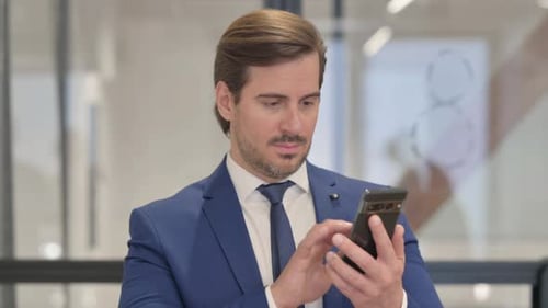 Businessman Using Smartphone in Modern Office