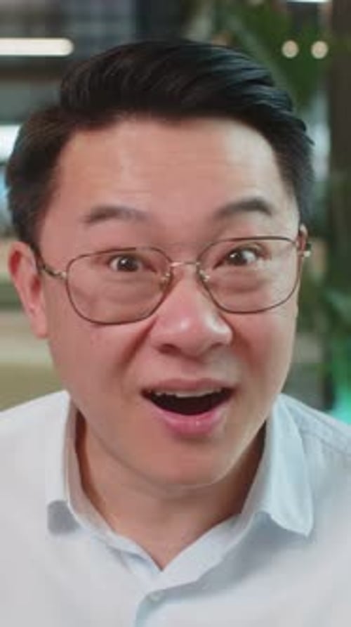 Chinese Young Businessman in Shirt Looking at Camera Shocked By Sudden Victory in Office Lobby