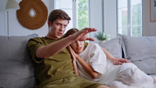 Relaxed Couple Lounging Comfortably on Sofa at Home