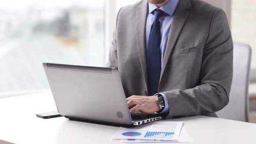 Businessman hands typing on laptop in office workplace technology and data compilation