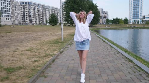 Beautiful Happy Woman Walking Along the Footpath in the Park