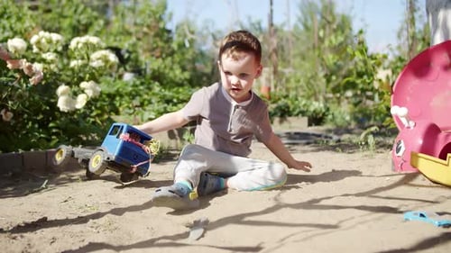 Boy Plays With Toy Truck In Backyard