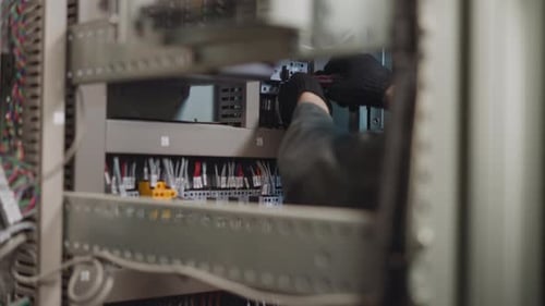 Electrician Working on Electrical Panel in a Factory