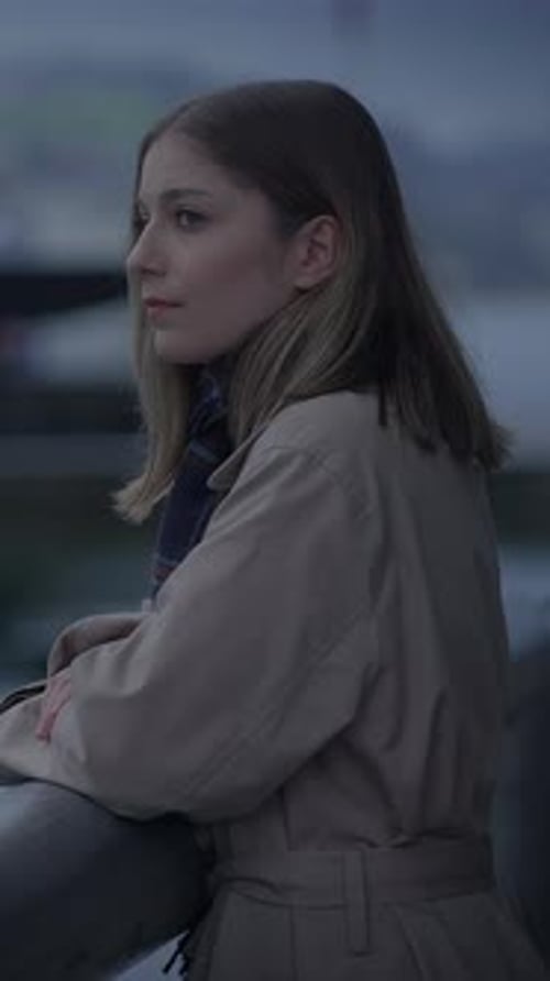 Thoughtful Woman Leans on Railing by Waterfront