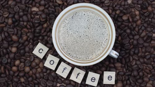 Top View of a Cup of Coffee on a Background Coffee Beans with the Inscription Coffee