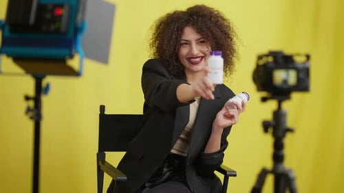 Woman Presenting White Bottles in Front of Camera