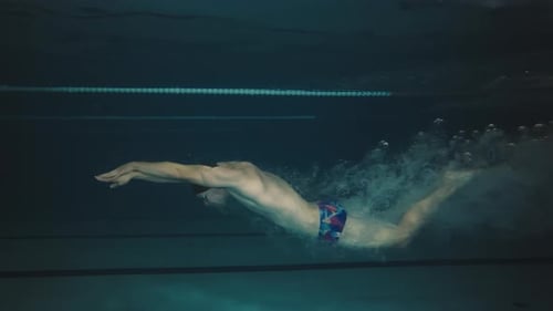 Un nageur professionnel s'entraîne dans la piscine Vue sous-marine Un nageur masculin nage pendant un entraînement de natation