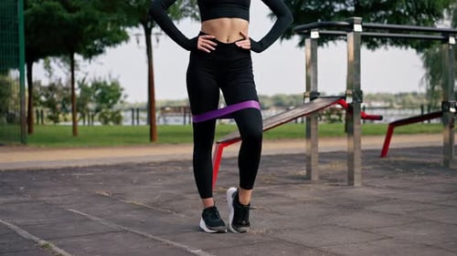 Close-up of Legs of a girl sports trainer performing exercises with an elastic band to strengthen
