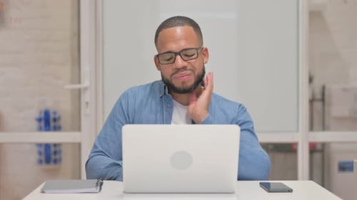 Man Rubs Sore Neck in Office