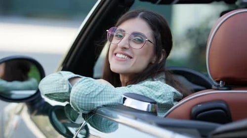 Woman Smiling in a Convertible Car in the City