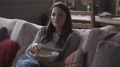 Woman Relaxing on Couch Eating Popcorn