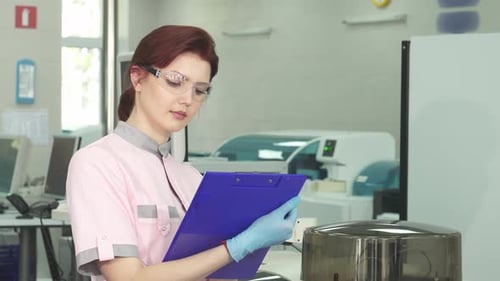 Woman Scientist Taking Notes in Modern Laboratory