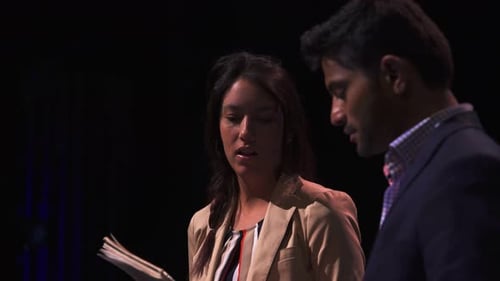 Two Adults Reviewing Notes in a Dark Setting