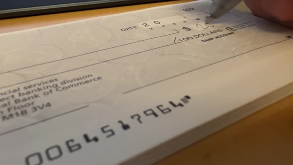 Firme a mano un cheque bancario sobre fondo de mesa de madera, cheque ...