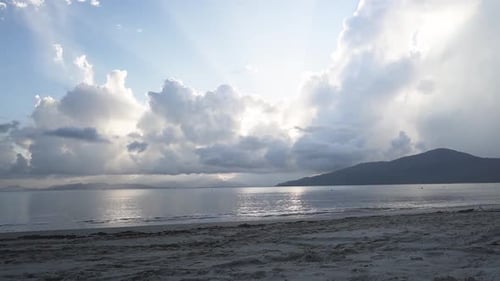 Timelapse de plage au coucher du soleil avec rayons de soleil à travers les nuages