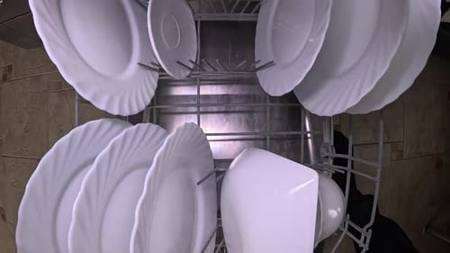 Plates and Cups Inside Open Stainless Steel Dishwasher