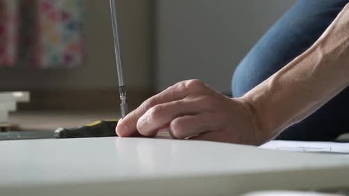 Person Assembling Furniture with a Screw Driver