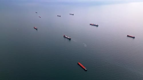 Luftaufnahme mehrerer Frachtschiffe, die über das ruhige offene Meer verstreut sind Die Höhepunkte der maritimen Szene