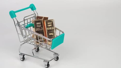 Gold bars in a small shopping cart symbolizing wealth, investment