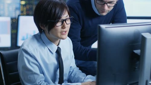 In the Data Mining Center Chief Statistician Consults His Young Assistant sits at His Workstation S