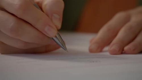 Close up of a woman signing important documents in a office setting