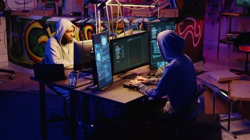 Two People Hacking Computers in Graffiti Room