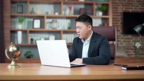 Dissatisfied with the results businessman looking at laptop computer screen in the office. Angry