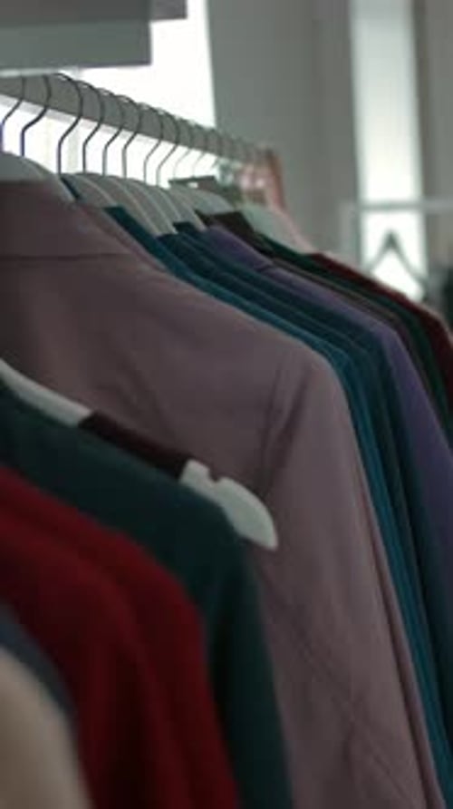 Vertical of Hangers with Trendy Clothes in Shop